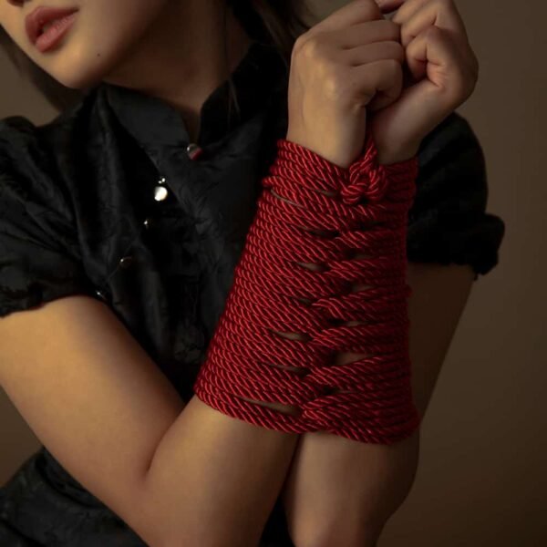 Corde Shibari de couleur rouge de la marque UPKO. Le mannequin porte un entrelacement de cordes d'une longueur de 10 m et d'un diamètre de cordon de 6mm.