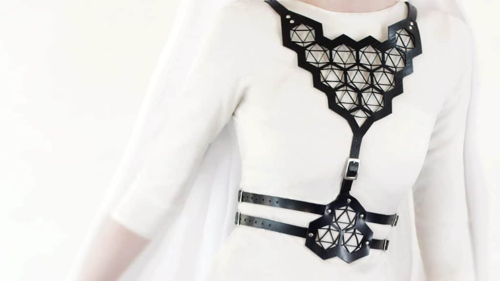 Black harness in vegetable leather with geometric patterns on a white background of Blasted Skin at Brigade Mondaine