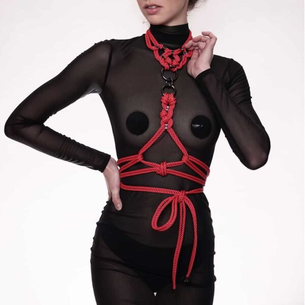 Megami red harness and collar set from Figure of A. The product is made from waxed cotton rope and silver zinc alloy beads. The harness is attached to the central ring of the collar with a clasp and is then tied around the body. The necklace is made up of a set of crossed strings and beads forming a circular pattern.