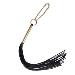 Cybele whip from the brand Elif Domanic. This product is made of black leather and golden brass. The handle is made of golden brass with a ring at the end where a chain made of an accumulation of golden balls is held.
