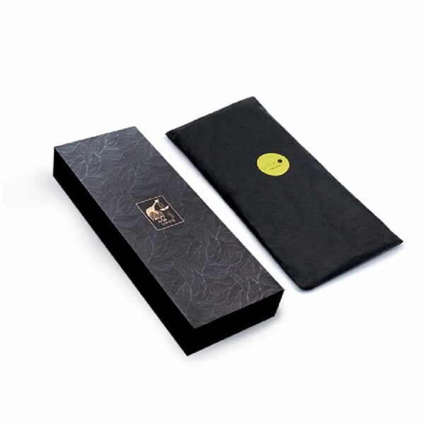 Emballage Upko noir. La boîte est rectangulaire avec des dessins tropicaux dessus et le logo Upko.