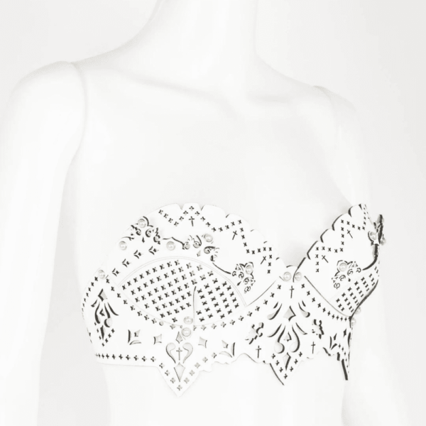 Bra from the Original Sin Bianco collection by Fraulein Kink by Brigade Mondaine. Entirely handcrafted to order in the brand's Berlin workshops from laser-cut patent leather, the Bianco bra is made to be seen. This meticulously laser-cut patent leather bra has removable straps and can be worn both over your favorite silk blouse or dress or directly on the skin. A very luxurious piece to draw attention in and out of the bedroom. Custom laser cut white patent leather bodice. Silver Pearl Ivory Double Cap Rivets. Adjustable and removable ivory bra straps. Adjustable stretch back hook closure.